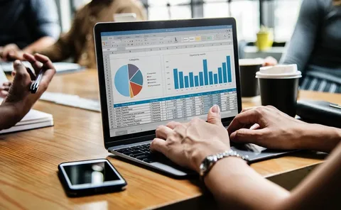 People analyzing business data on a laptop in a conference room.