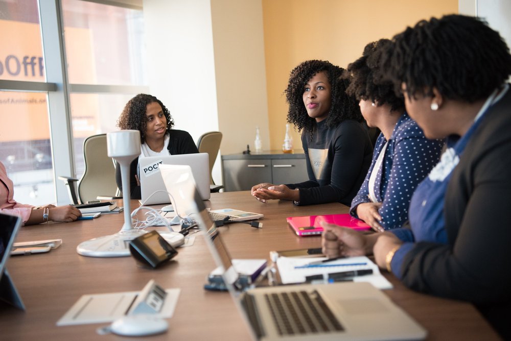 A woman speaks to a group during a meeting in a conference room.
